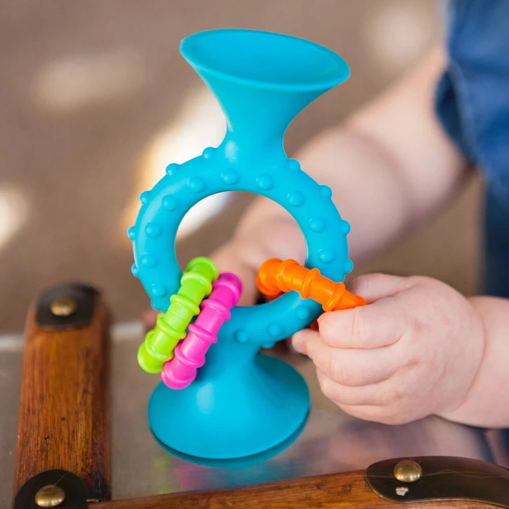 Sensoryczna zabawka z przyssawką Bobo Fat Brain Toys (6m+). Silikonowy gryzak i grzechotka do krzesełka do karmienia lub kąpieli. Idealny prezent dla niemowlaka na ząbkowanie, który wspiera rozwój chwytu i nie spada na podłogę.