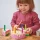 Tęczowy drewniany tort urodzinowy do krojenia marki Tender Leaf Toys z białym lukrem, 6 kolorowymi świeczkami i drewnianą łopatką