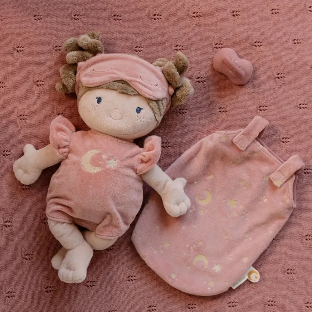 Duża lalka Little Dutch Rosa w różowej piżamce leżąca w materiałowym śpiworku