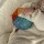 Lekka sensoryczna piłka z wbudowaną cichą grzechotką niemieckiej marki sigikid. Kolorowa pluszowa piłeczka dla niemowląt o średnicy 11 cm z materiałową pętelką do wózka, bezpieczna miękka zabawka rozwojowa od 3 miesięcy.